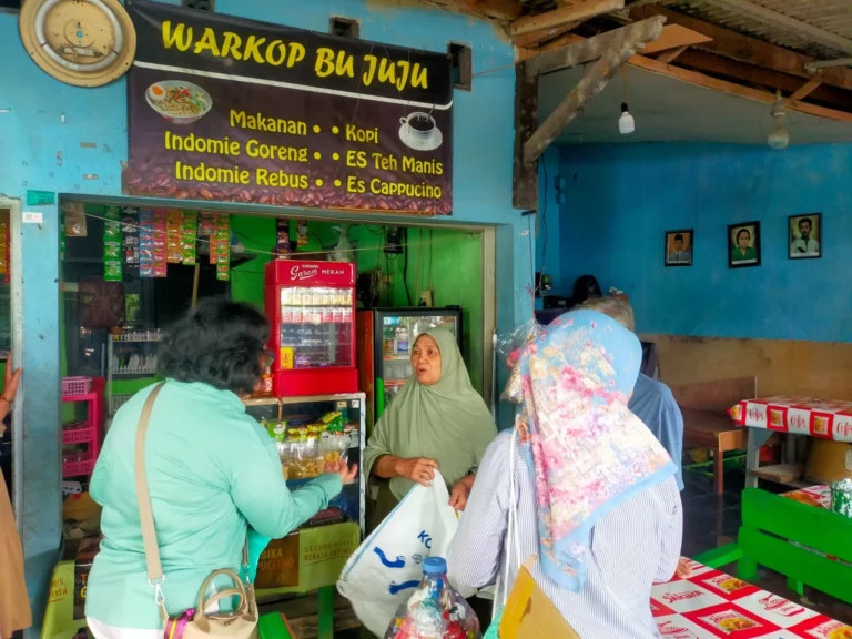 Perwakilan Dinas LH dan ibu-ibu Kompak membagikan tas wadah hasil pemilahan sampah kepada warga RT 11 Kelurahan Srengseng Sawah yang membuka warung di kawasan Setu Babakan, Minggu (25/1/26).