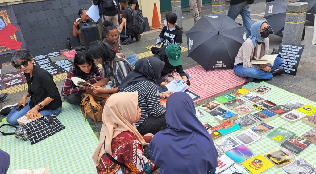 Kegiatan membaca buku di lapak perpustakaan jalanan dalam aksi tolak gelar pahlawan Soeharto di Jakarta, Juni 2025. (foto: dok. Konde.co/Salsabila Putri Pertiwi)
